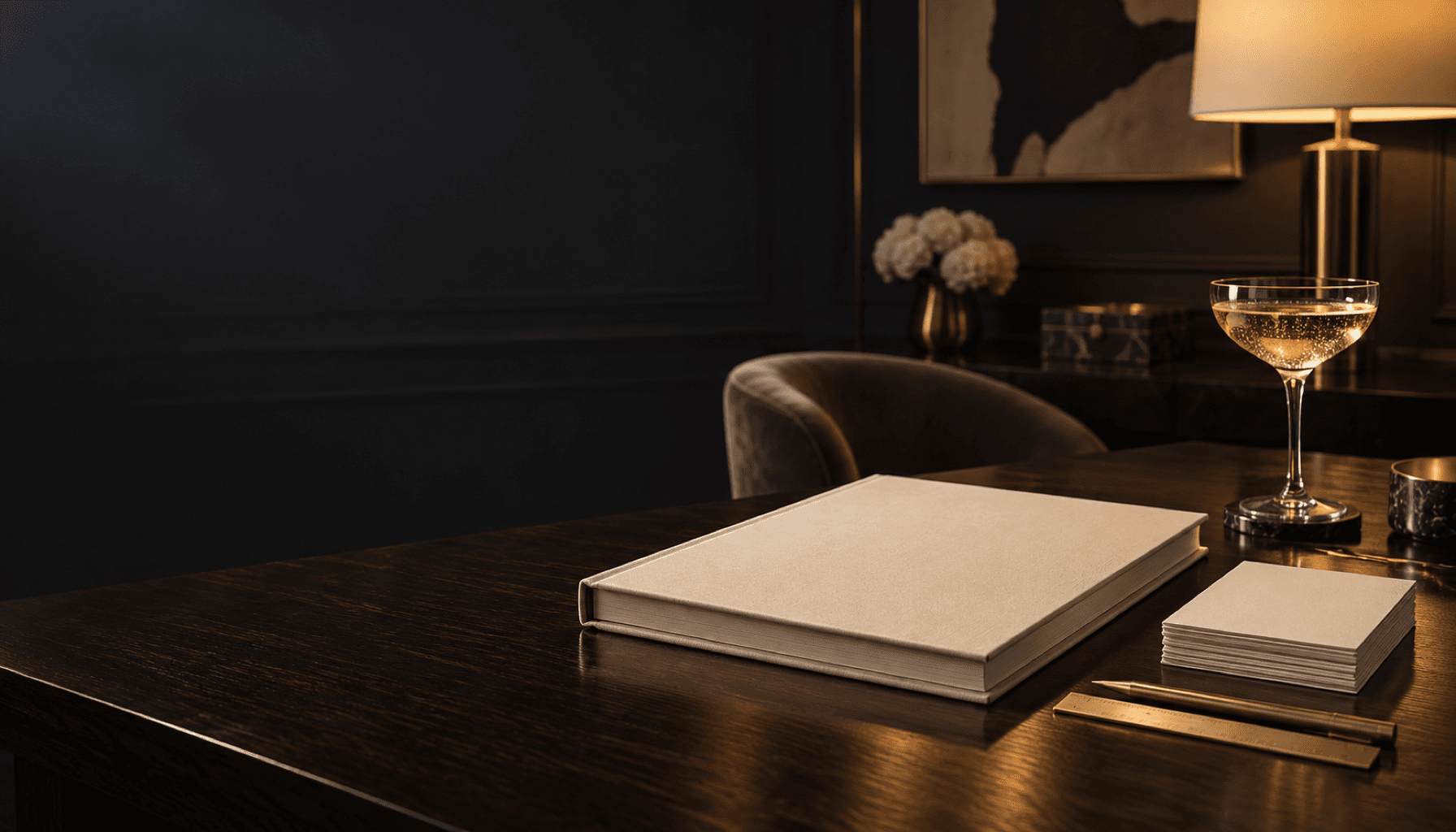 A folded cream note beside a small stack of blank cards on a charcoal table in warm light.